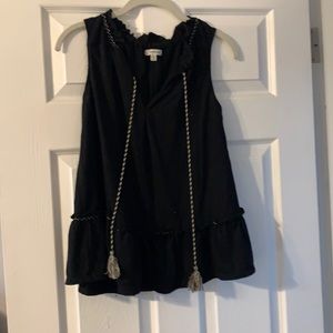 Black sleeveless top. Ruffle around the collar
